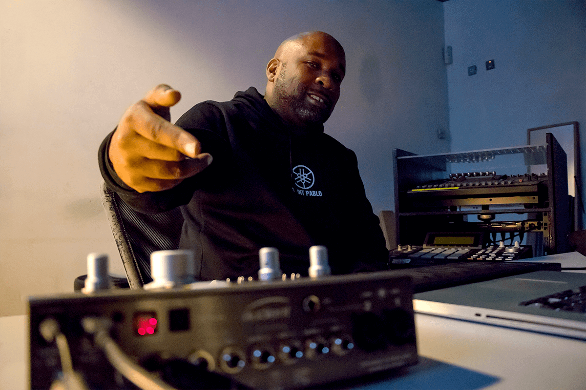 Chris Brown gesturing to camera behind studio outboard gear